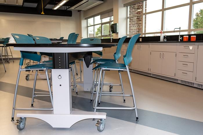manual height adjustable Symbiote WorkTable on casters with phenolic surface surrounded by chairs at Marist High School